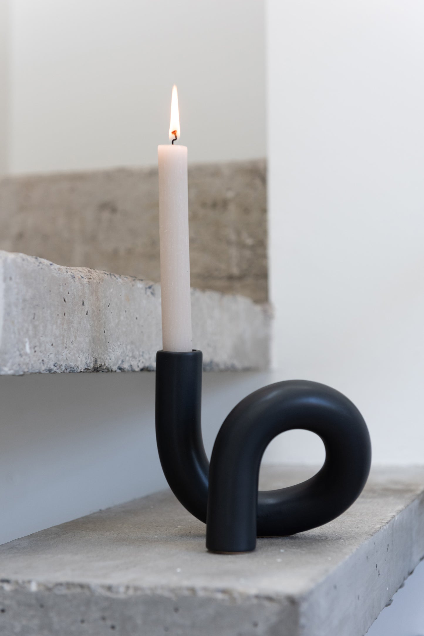 Kaarsenhouder Torsie 1 Candle Keramiek Zwart met brandende kaars op betonnen trap sfeerfoto felika