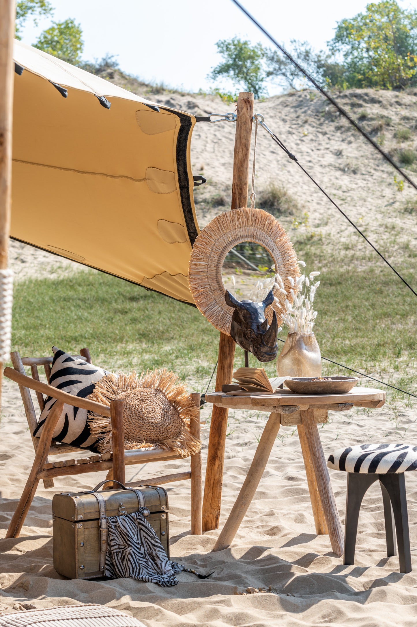 Spiegel Hangend Rond Riet Raffia Naturel sfeerfoto in het zand met stoel krukje tafel eenhoorn beeldje vaas met witte bloemen